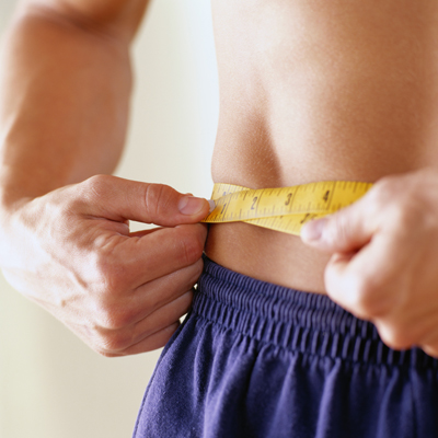 Close-up of a man measuring his waist