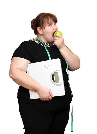 Overweight woman with scales and apple