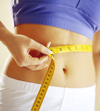 Woman measuring her waist