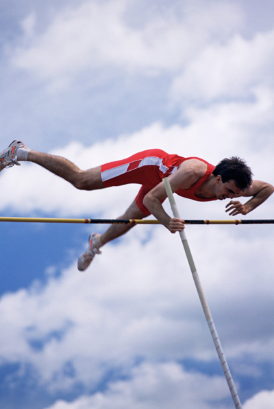 Man in mid air doing pole vault Man in mid air doing pole vault